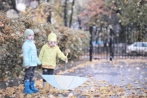 Les enfants marchent dans le parc première neige — Photo