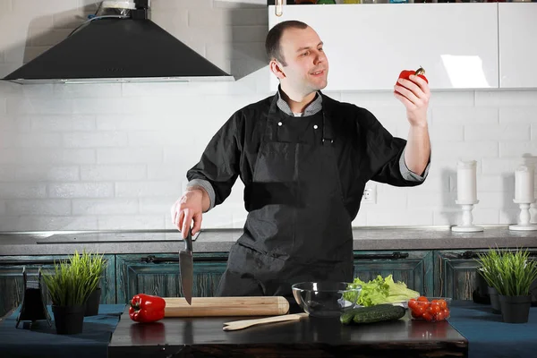 Man cook preparing food at the kitchen table of vegetable