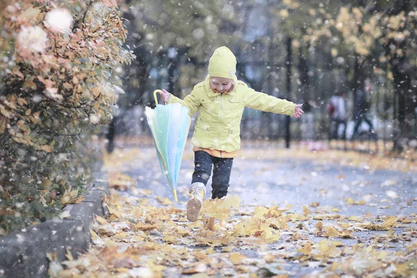 子供たちは公園の最初の雪の中を歩く — ストック写真