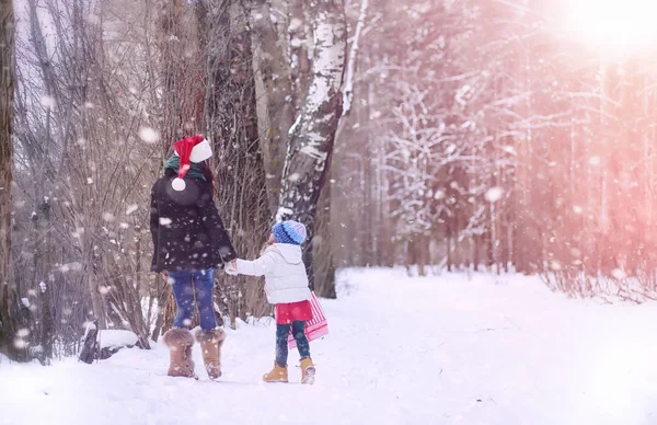 A winter fairy tale, a young mother and her daughter ride a sled