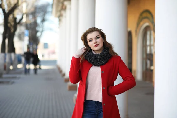 Menina bonita em um passeio em casaco vermelho na cidade — Fotografia de Stock