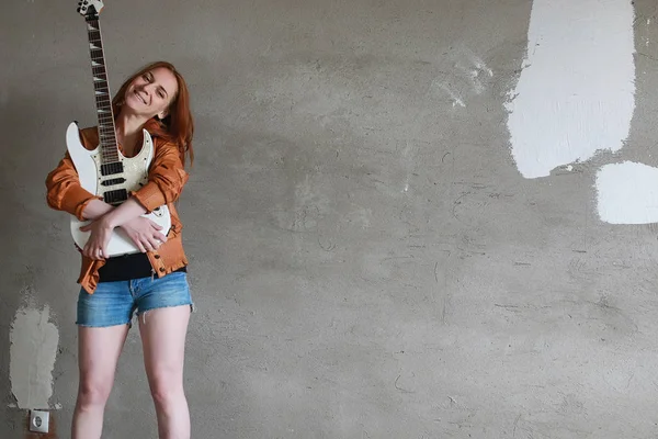 Menina ruiva jovem com uma guitarra elétrica. Músico de rock gir — Fotografia de Stock