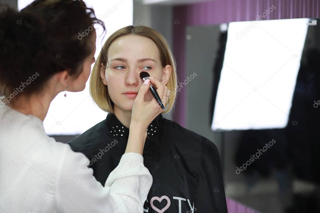 Young girl with a make-up artist