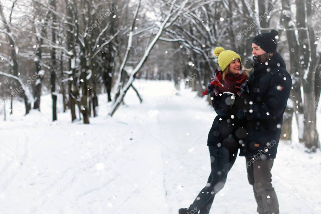 young lovers waling in snowy winter park