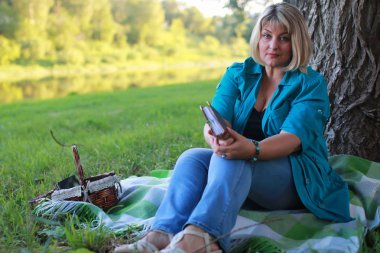 kadınla çimenlerin üzerinde kitapla Park