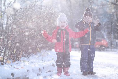 Çocuklar parkta ilk kar yürümek