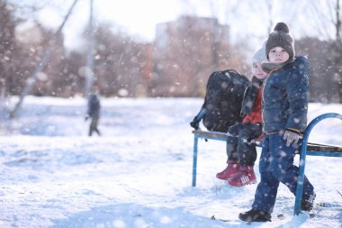 Çocuklar parkta kuşları besler. 