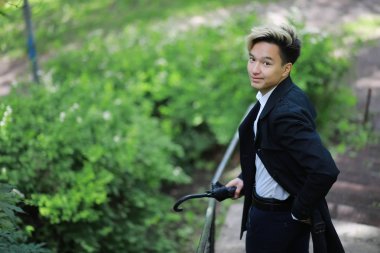 Bahar yağmurlu hava ve bir şemsiye ile genç bir adam