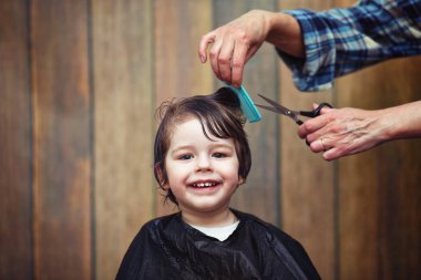Küçük bir çocuk kuaförde kesilmiş. 