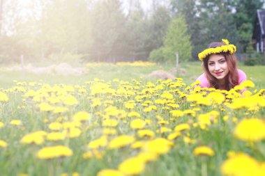 Sarı dandelions çayırda güneşli bir dinlenme kız