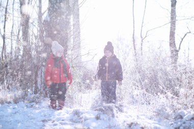 Çocuklar parkta ilk kar yürümek