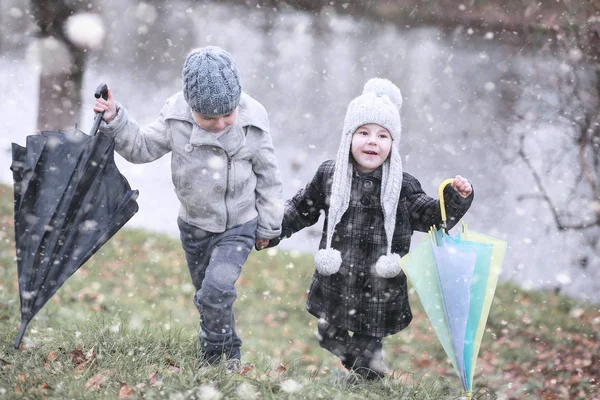 Les enfants marchent dans le parc première neige — Photo