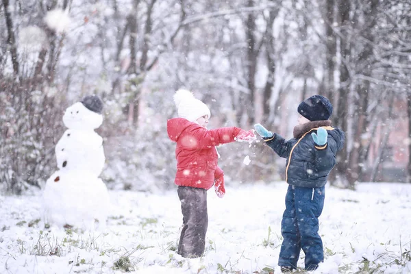 Kinderen lopen in het Park eerste sneeuw — Stockfoto