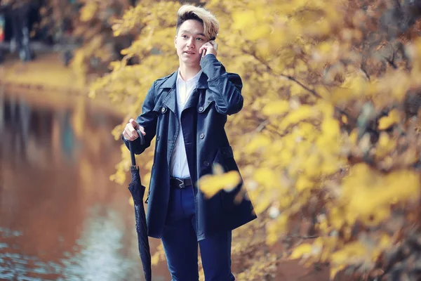 Automne temps pluvieux et un jeune homme avec un parapluie — Photo