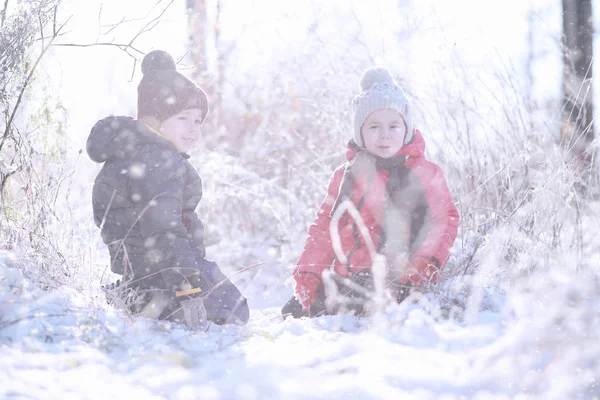 Dzieci chodzą w parku pierwszy śnieg — Zdjęcie stockowe
