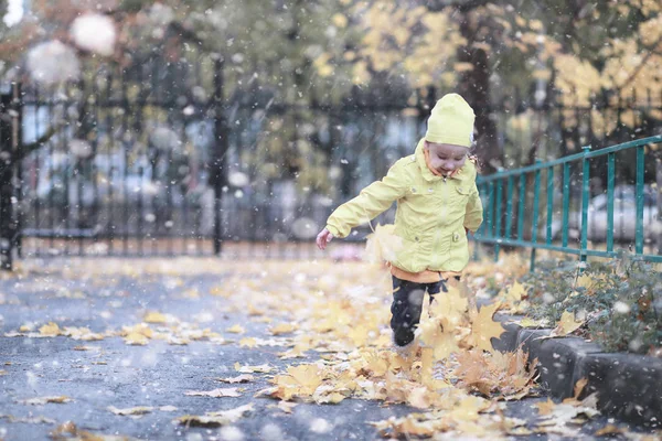 子供たちは公園の最初の雪の中を歩く — ストック写真