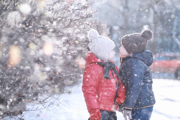 Les enfants marchent dans le parc première neige — Photo