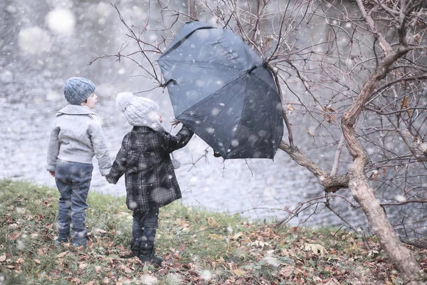 I bambini camminano nel parco prima neve — Foto Stock