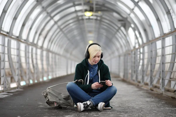 Fiatal lány hallgatja a zenét nagy fejhallgató a metróban — Stock Fotó