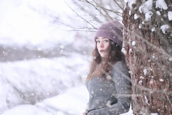 Girl in a winter park in snowfall — Stok Foto