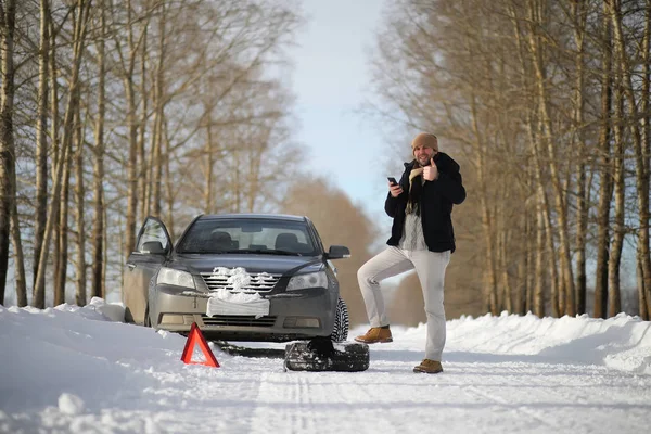 A man near a broken car on a winter day — Stock Photo, Image