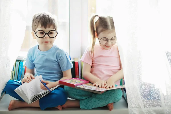 Kinderen liggen op het bed naast de pasgeboren baby, zusje. — Stockfoto