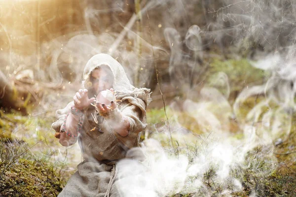 Un homme en soutane passe un rituel dans une forêt sombre — Photo