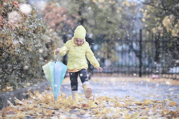 子供たちは公園の最初の雪の中を歩く — ストック写真