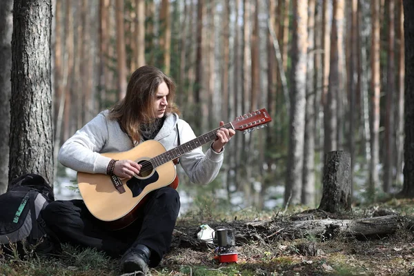 Guitarrista na floresta num piquenique. Um músico com um acústico — Fotografia de Stock