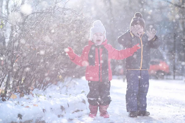 Crianças caminham no parque primeira neve — Fotografia de Stock