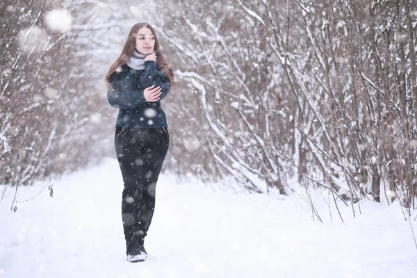 Ragazza in un parco invernale in nevicata — Foto Stock