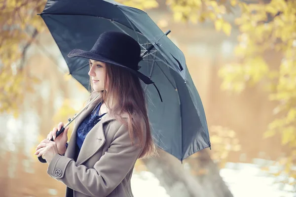 Autumn rainy weather and a young man with an umbrella — Stock Photo, Image