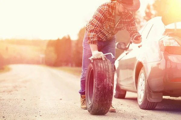 Man sitter på vägen av bilen — Stockfoto