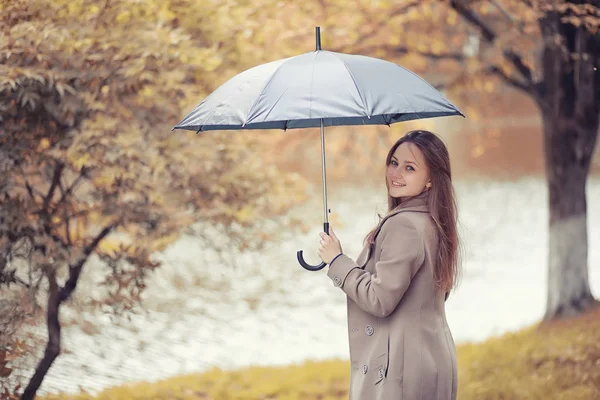 Sonbahar yağmurlu hava ve bir şemsiye ile genç bir adam — Stok fotoğraf