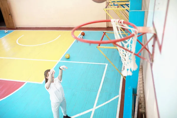 Дівчина в спортзалі грає в баскетбол — стокове фото