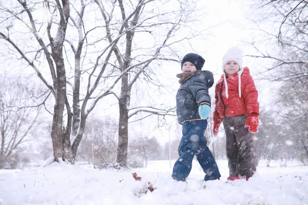 I bambini camminano nel parco prima neve — Foto Stock