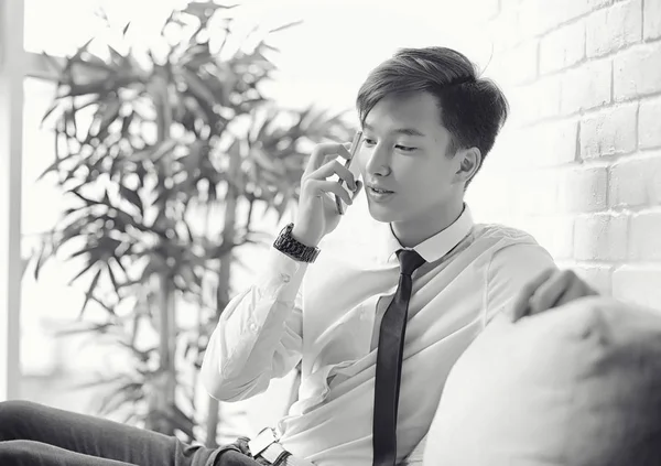 Genç bir Asyalı işadamı bir kafede ortak bekliyor. Bir kafede Koreli genç bir adam telefonda konuşuyor.