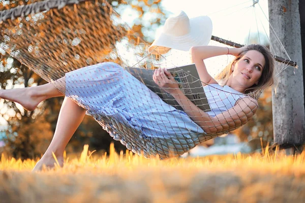 Hermosa chica en hamaca leyendo un libro —  Fotos de Stock