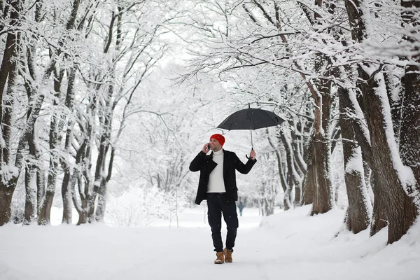 一个人在公园里散步。 在冬季雪地里的年轻人a — 图库照片