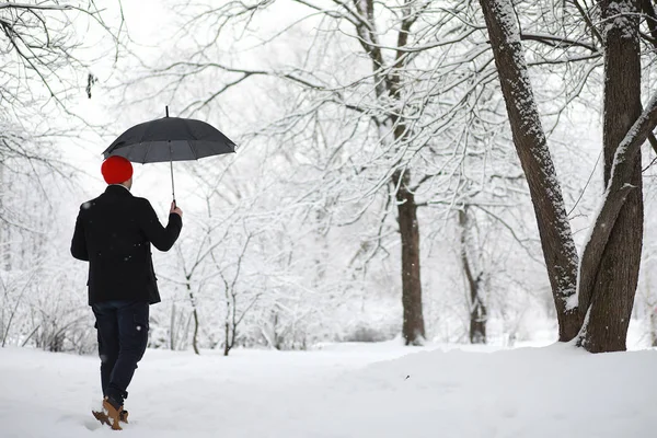 Um homem a passear no parque. Jovem com no inverno snowfa — Fotografia de Stock