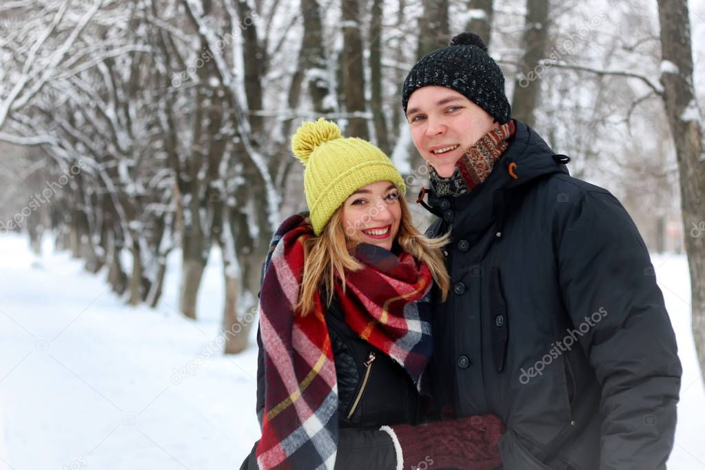young lovers  waling in snowy winter park