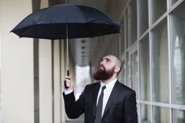 Takım elbiseli kel sakallı bir adam.