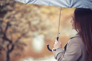 Sonbahar yağmurlu hava ve bir şemsiye ile genç bir adam
