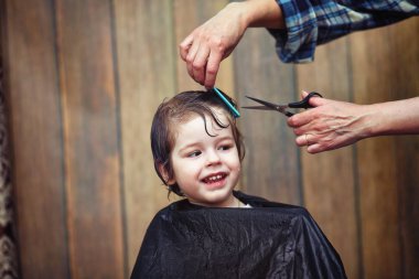 Küçük bir çocuk kuaförde kesilmiş. 