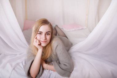 Sarı saçlı ve gri kazaklı kız.