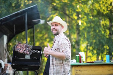 Barbekü ızgarası hazırlayan bir adam. Doğayla ilgili öğle yemeği.