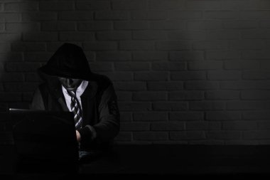 Siyah maske ve hood masada hacker