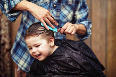 Küçük bir çocuk kuaförde kesilmiş. 