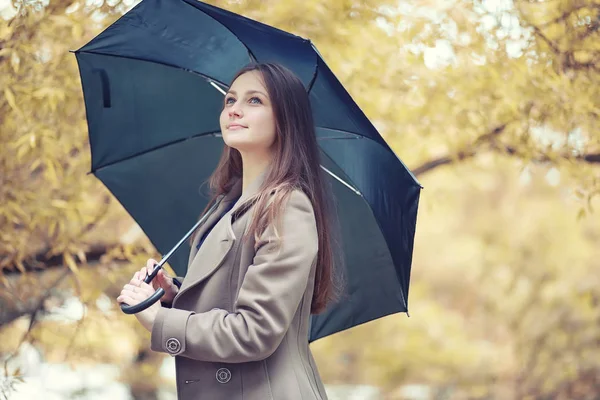 Autunno tempo piovoso e un giovane uomo con un ombrello — Foto Stock