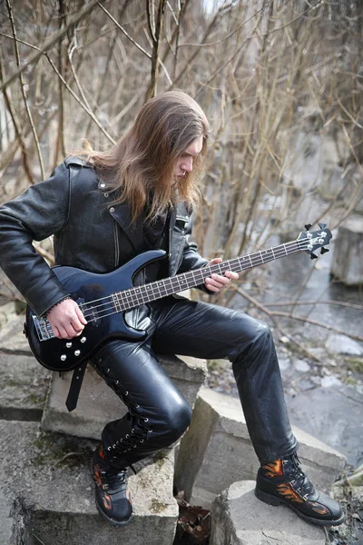 Rockgitarist op de trappen. Een muzikant met een basgitaar in een — Stockfoto